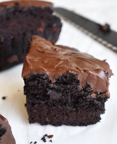 a piece of chocolate cake sitting on top of a white plate next to a knife