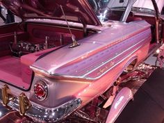 an old car with pink paint and chrome trim