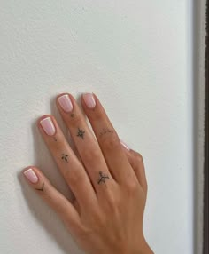 a woman's hand with pink manicures and stars on her left thumb