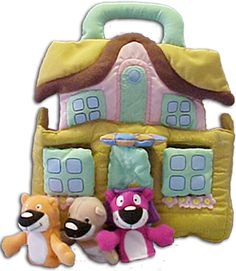 three stuffed animals sitting in front of a doll house