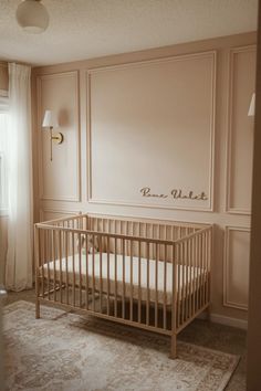 a baby's crib in the corner of a room with white walls and carpet