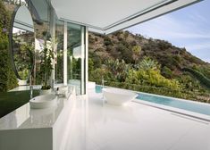 a bathroom with two sinks and a large mirror on the wall next to an outdoor swimming pool