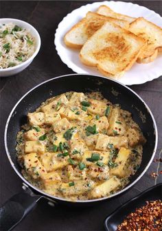 a pan filled with food next to some bread