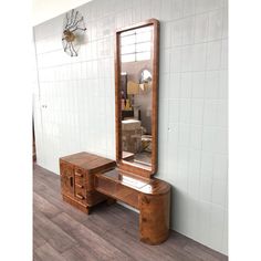 a mirror sitting on top of a wooden table next to a dresser with drawers underneath it