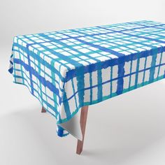 a blue and white checkered tablecloth on a wooden leg with an upclose design