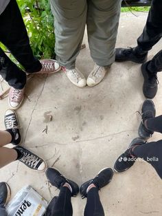 several people standing in a circle with their feet on the ground