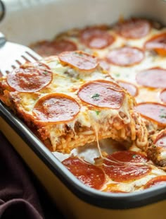 a close up of a slice of pizza on a pan with a fork in it