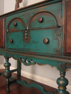 an old dresser is painted teal green