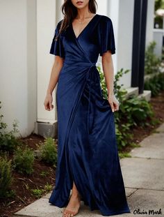 a woman in a blue dress is walking down the sidewalk