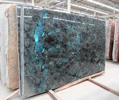 green marble slabs in warehouse with blue veining on the top and bottom side