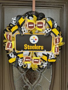 a wreath with footballs on it is hanging from the front door to be decorated