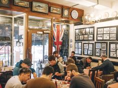 people sitting at tables in a restaurant with pictures on the wall