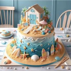 there is a blue and white cake with shells on the table next to it,