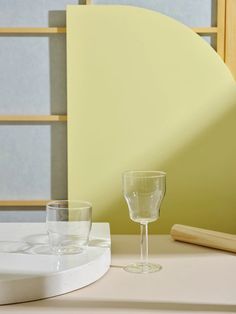 two empty wine glasses sitting on top of a table next to a rolling board and roller