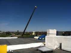 a crane is on the roof of a building that has been torn down and covered with tarps