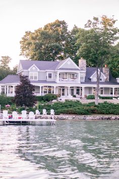 a large white house sitting on top of a lake