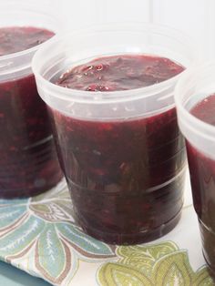 three plastic cups filled with jelly sitting on top of a table