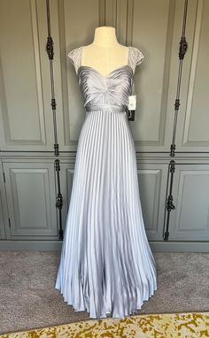 Gorgeous, nwt gown by Aidan Mattox, a nice label that is carried in places like Nordstrom and Macy's.  Size 2, includes extra beads.  Stunning blue/grey/silver color.  Measurements are:  bust 32" x waist 26.5" x hips 37".  Length from top of shoulder seam to hem is 60"; from underarm to hem is 53". Silver Outfit, Silver Outfits, Silver Gown, Aidan Mattox, Bridal Shop, Character Outfits, Dress Clothes For Women, Silver Color, Blue Grey