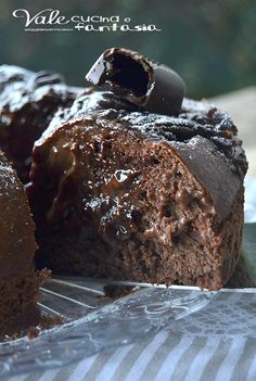 a chocolate cake is cut into pieces and sitting on foil