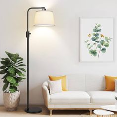 a living room with a white couch and green plants on the wall next to it