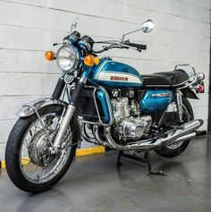 a blue motorcycle parked next to a white brick wall