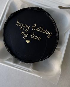 a black cake with gold writing on it