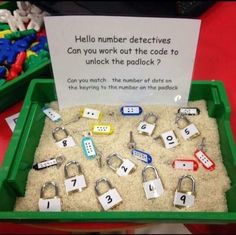 a green tray filled with lots of sand and magnets next to a sign that says keys and locks with numbers on them