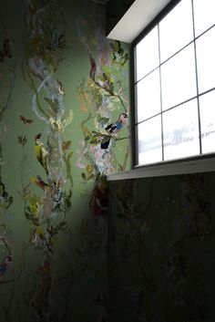 a bathroom with green walls and colorful wallpaper