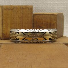 "Sterling silver and 1/20th 12KGF cuff bracelet. Stamped Sterling Mark Yazzie. 11/16\" wide. The inside measures 6 3/8\" including the 1 5/16\" opening. This is a small man's or large woman's bracelet. It can not be sized up or down because of the inset gold filled design. Good condition. Shipped by US mail. SBT-6" Gold Sterling Silver Cuff Bracelet, Unique Engraved Gold Cuff Bracelet, Unique Gold Sterling Silver Cuff Bracelet, Unique Gold Engraved Cuff Bracelet, Unique Gold Etched Cuff Bracelet, Classic Gold Sterling Silver Cuff Bracelet, Gold Sterling Silver Cuff Jewelry, Gold Sterling Silver Cuff Bracelet With Polished Finish, Black Onyx Ring