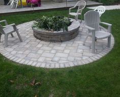 an outdoor fire pit with chairs around it