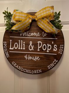 a welcome sign for lolli & pops house with yellow gingham bows on it