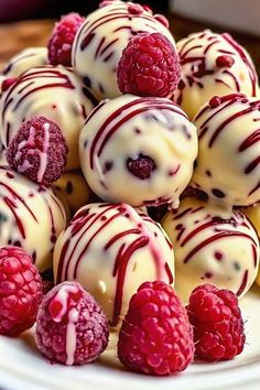 a white plate topped with raspberries and chocolate covered truffles on top of each other