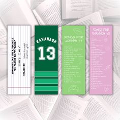 three bookmarks with the names and numbers of various books on them, all in different colors