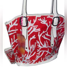 a red and white handbag with coral print on the front, featuring two handles