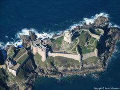 an aerial view of a castle in the ocean