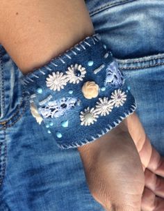 a close up of a person wearing a blue bracelet with flowers and beads on it