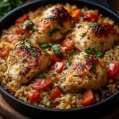 chicken and rice with tomatoes in a skillet on a wooden table, ready to be eaten