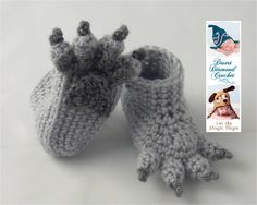 a pair of crocheted slippers with a book in front of it and an image of a dog wearing a crown