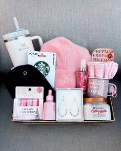 the contents of a woman's purse sitting on a couch next to a coffee cup