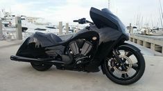 a black motorcycle parked on top of a pier