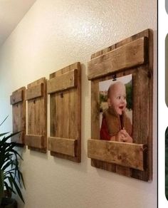 three wooden frames with pictures hanging on the wall next to a potted plant in front of them