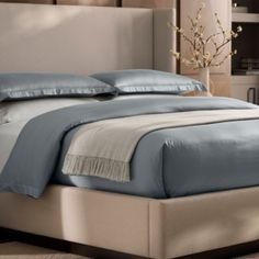 a bed with blue sheets and pillows in a room