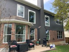 an outside view of a house with furniture on the front lawn and back yard area