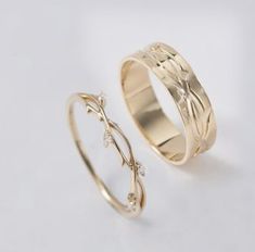 two gold wedding rings with diamond accents on each side, one in yellow gold and the other in white gold