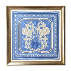 a blue and white cross stitched design in a wooden frame