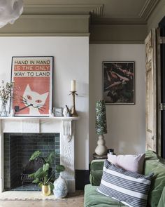 a living room filled with furniture and a fire place in front of a painting on the wall