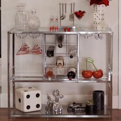 a metal shelf filled with lots of glassware on top of a hard wood floor