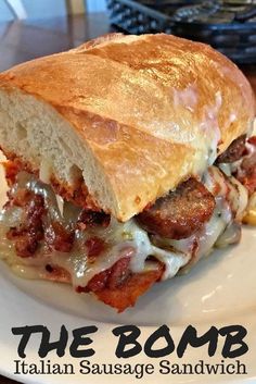 a close up of a sandwich on a plate with the words the bomb italian sausage sandwich