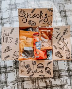 snack boxes with snacks in them on top of a table covered in writing and doodles