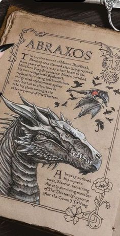 an old book with a drawing of a dragon on it's cover and a pen resting next to it